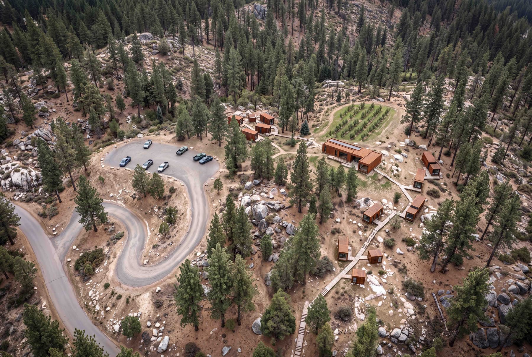 The property from above: the access road, the clearing, and the cabins in the trees