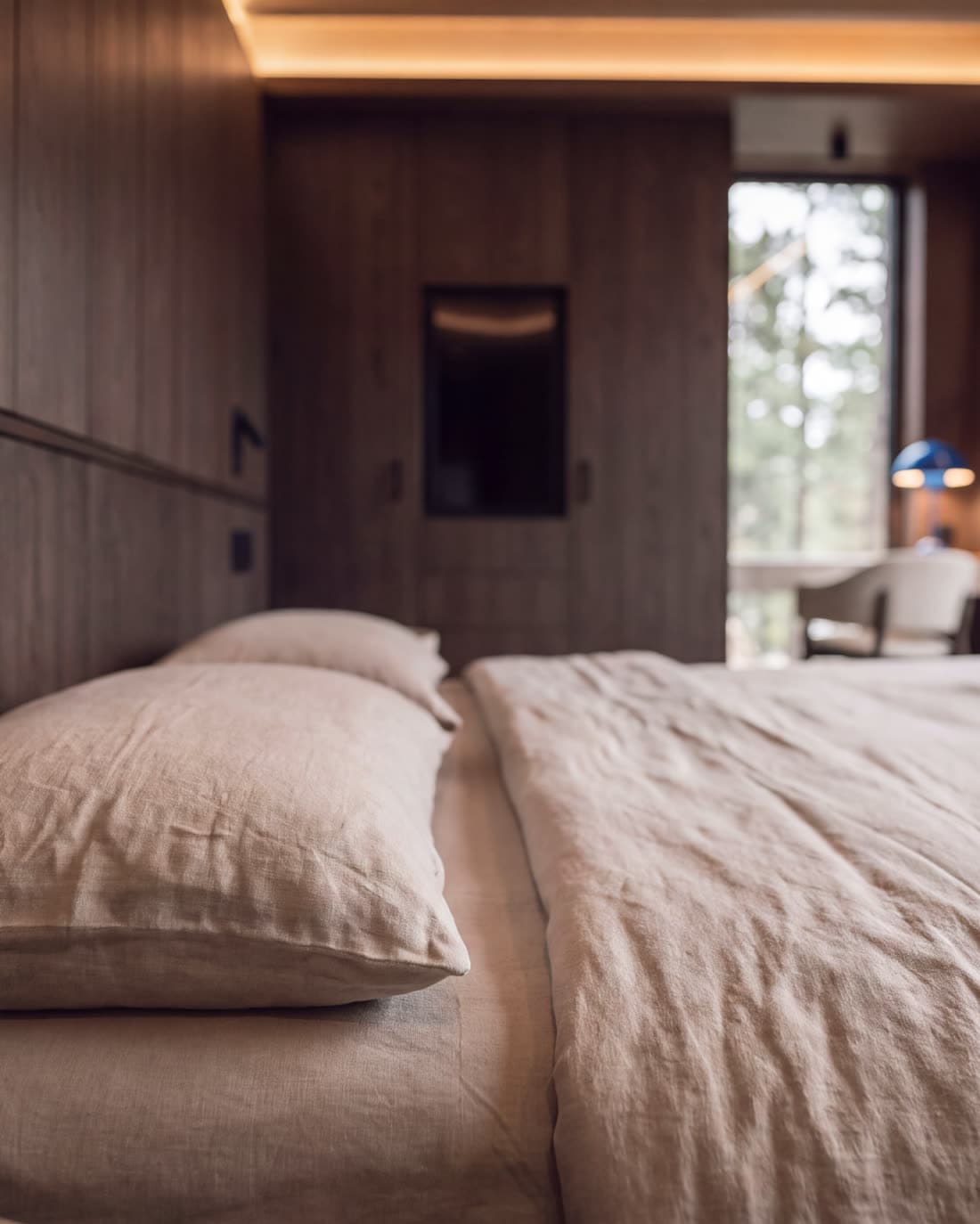 The bed, with the pack and jacket hung by the window